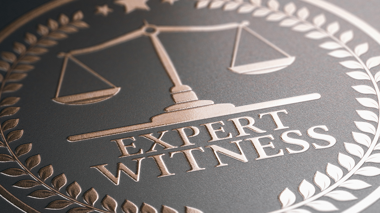 Expert witness logo dark background with brass colored Scale of Liberty.