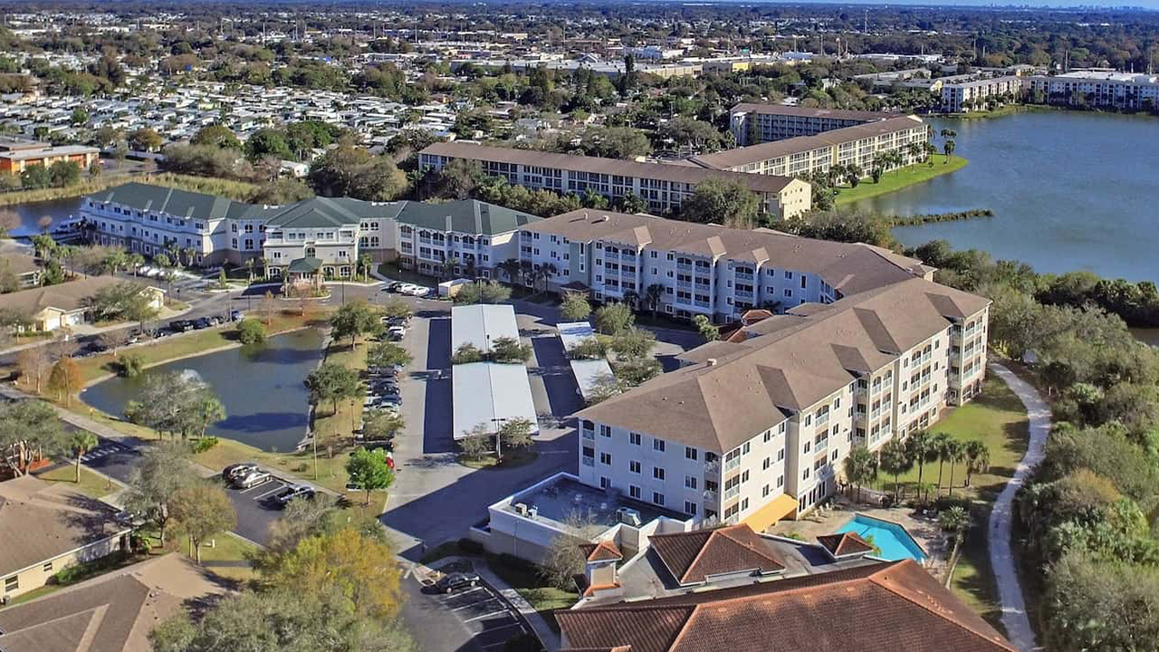 NCR Bradenton sky view. The property is comprised of multiple adjoining buildings with lakes and palm trees.